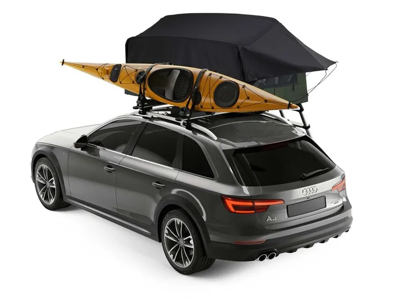 Thule Foothill half-width softshell rooftop tent mounted alongside a kayak on the roof of an Audi A4 wagon