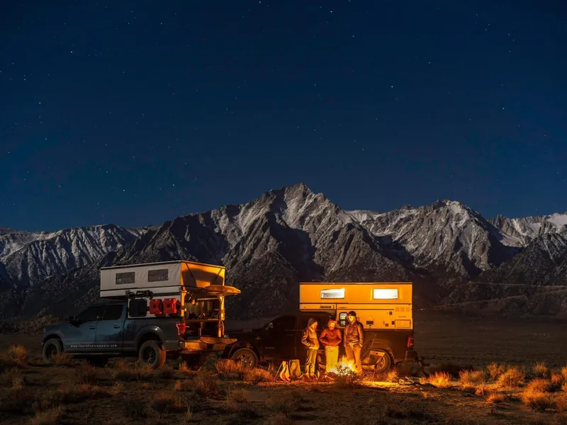 Four Wheel Campers Hawk pop-up slide-in camper on a pickup at dusk